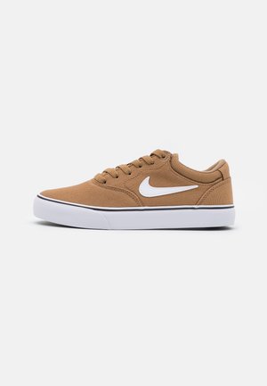 Brun lavtopsneaker med hvid sål og hvid Nike swoosh-logo på siden, vist fra ydersiden.