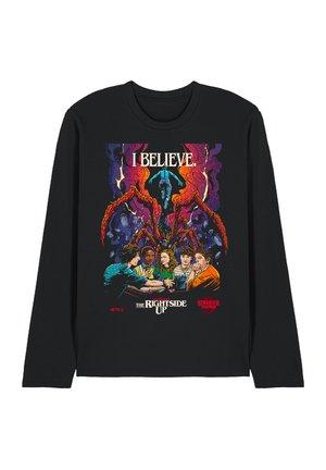 Black long-sleeve shirt with colorful Stranger Things design showing five kids, a large red monster, and the text "I BELIEVE" and "The Right Side Up."