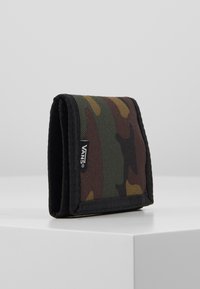 Portfel w wzór kamuflażu wykonany z trwałego materiału, z czarnymi akcentami i metką z logo Vans z boku. Kompaktowy, składany design.