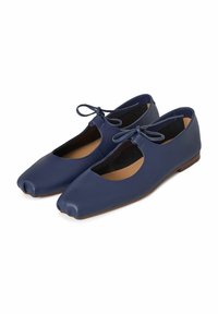 Bailarinas de cuero azul marino con puntas redondeadas, lados abiertos y un lazo delgado en la parte delantera. Suelas planas con una textura suave.
