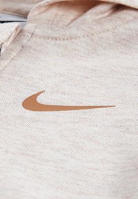 Φούτερ Nike σε ανοιχτό μπεζ ύφασμα με απαλό ύφασμα, διαθέτει καφέ κεντητό λογότυπο swoosh στο στήθος.