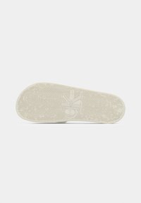Sneakersåle i off-white gummi, med et teksturert gripe-mønster og preget logo. Flat design med avrundet kant for komfort.