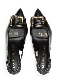 Zapatos de tacón de piel negra tipo slingback con puntera afilada, que presentan una hebilla rectangular dorada y una textura suave. Nombre de la marca 'Martinielli' visible.
