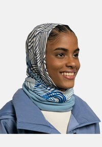 Pañuelo multicolor con patrones de olas en azul y blanco, hecho de un tejido suave, superpuesto a un calentador de cuello de felpa azul claro.