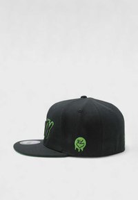 Musta snapback-lippis, jossa vihreä kirjailtu "NY"-logo ja sivulla pisaravaikutteinen pyöreä logo. Suorakulmainen lippa.