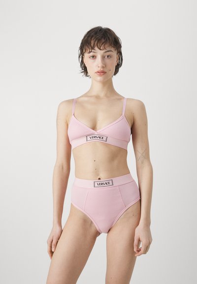 Rózsaszín bordázott bralette és magas derekú alsónemű szett állítható pántokkal és Versace logóval a derékrészen.