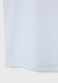 Witte katoenen T-shirt met een gladde textuur, voorzien van een ronde zoom en subtiele steekdetails langs de onderrand.