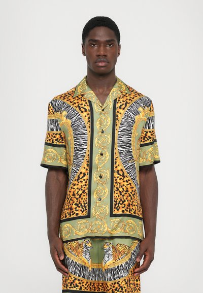 Kortærmet skjorte i livlige mønstre med gyldne accenter, leopard- og zebra-mønstre samt tigermotiver på grønt stof.