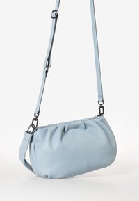 Helle blaue Lederhandtasche mit gerafftem Design, verstellbarem Trageriemen und metallischen Akzenten. Glatte Textur, ovale Form.
