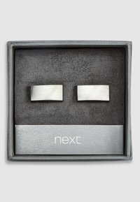 Cufflinks od nehrđajućeg čelika u pravokutnom obliku s četkanom završnom obradom, predstavljeni u sivoj kutiji obloženoj crnim antilopom.