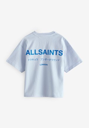 Gaišblue kokvilnas T-krekls ar īsām piedurknēm, kam ir izteiksmīgs zils teksts: "ALLSAINTS," Japāņu rakstzīmes un "LONDONA" aizmugurē.
