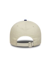 Casquette de baseball beige avec un bouton bleu sur le dessus et une sangle arrière ajustable avec un fermoir en métal, fabriquée dans un matériau doux et texturé.