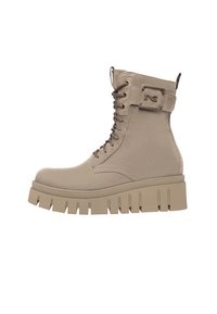 Bottines beiges à lacets avec un dessus texturé, semelle épaisse et un détail de boucle sur le côté pour plus de structure.