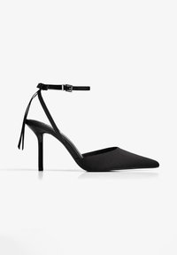 Scarpa nera con tacco alto, punta affusolata, materiale simile alla satinato, cinturino alla caviglia con fibbia e tacco slim a stiletto.