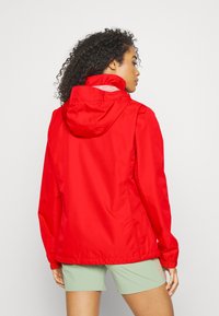 Rød lett jakke med hette, med en glattekstur og elastiske mansjetter. En enkel design med en litt tilpasset silhuett.