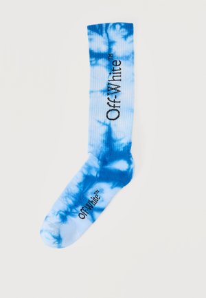 Chaussette tie-dye bleu et blanc avec le texte "Off-White" imprimé en noir, verticalement sur le mollet et horizontalement sur le pied.