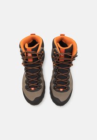 High-top hiking boots in gray and black with orange accents. Features textured fabric, reinforced toe, and black laces for secure fit.