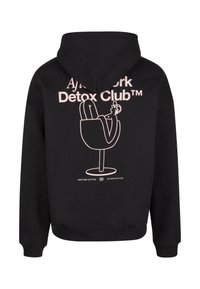 Black hoodie made of cotton featuring a pink graphic design on the back, stating "Aj's York Detox Club" with a lounging figure illustration.