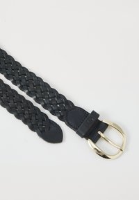 Cintura in pelle nera intrecciata con fibbia in metallo color oro. Presenta un design piatto e intrecciato con estremità lisce. Progettata per una chiusura regolabile.