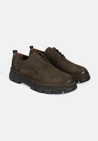 Chaussures en daim marron avec un bout arrondi, un design à lacets et une semelle en caoutchouc noire épaisse avec des rainures pour l'adhérence.