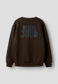 Felpa marrone con una texture morbida, presenta una grande grafica "BON JOUR" multicolore sul retro. Polsini e orlo a coste.