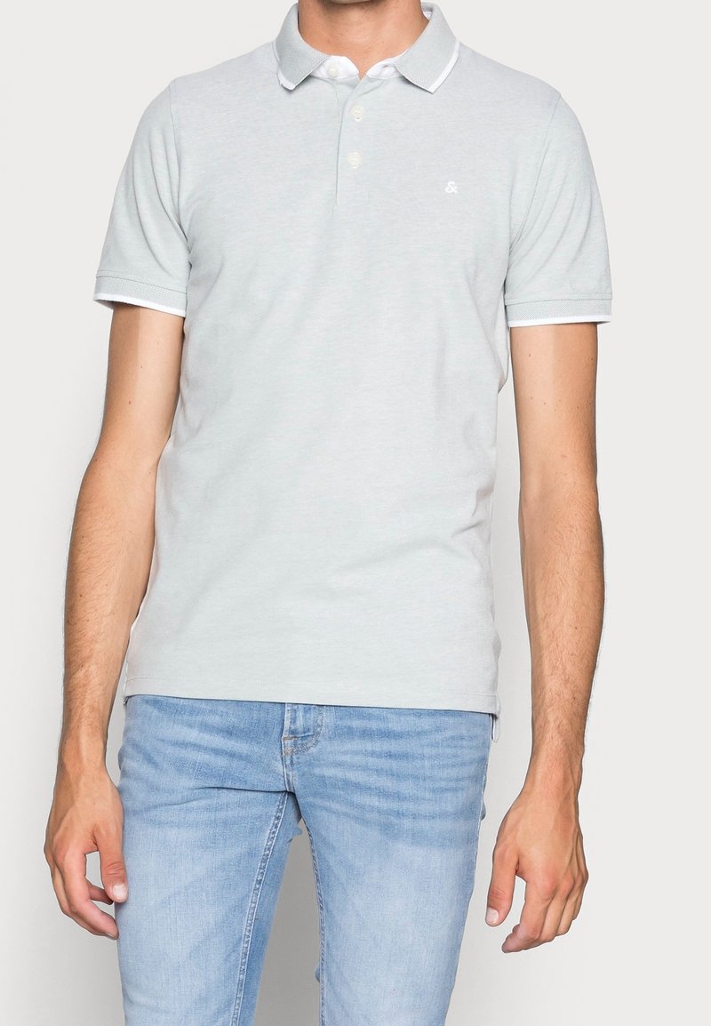 Light gray polo shirt with a classic collar, white accents around the collar and sleeves, made of soft cotton fabric, fitted design.