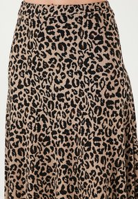 Maxi rok met luipaardprint gemaakt van ribbelstof; heeft zwarte vlekken op een lichtbruine achtergrond; elastische tailleband.