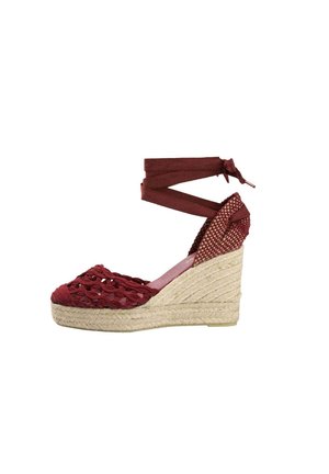 Sandalia espadrille de cuña con suela trenzada de yute natural, parte delantera de crochet burgundy y cierre de lazo en el tobillo.