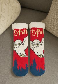 Calze rosse a tema Harry Potter con design di un gufo bianco, morbido risvolto bianco e dettagli blu; presenta motivi forestali sul fondo.