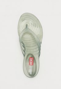 Transparent grøn flip-flop med bølgete tekstur på fodsengen og glatte remme; har rødt logo på sålen.