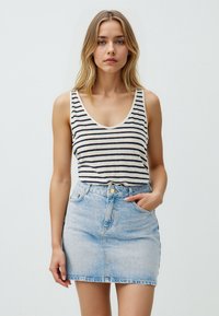 Gestreept tanktop in crème en marineblauw, gecombineerd met een lichtblauwe denim miniskirt. Rok heeft voorzakken en een knoopsluiting.