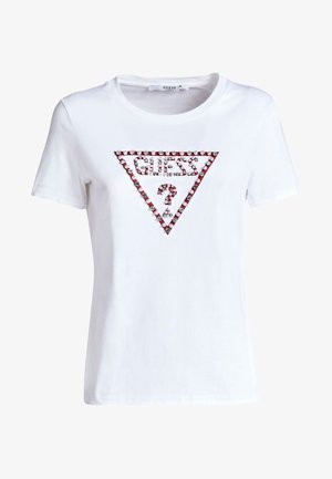 Camiseta de algodón blanca con mangas cortas. Presenta un diseño triangular con adornos rojos y plateados que dicen "GUESS?" en el centro.