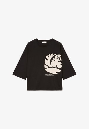Zwart shirt met lange mouwen met een beige abstract bladontwerp en de tekst "the ART EDITION" gedrukt op de rechteronderkant aan de voorkant.