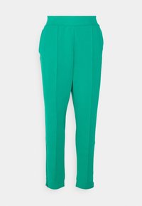 Pantalones verdes, ajustados y acampanados, confeccionados con material elástico, cinturilla plana, bolsillos laterales y detalles con cremallera en los puños. Textura suave.