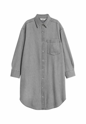 Grå denimskjorte med knaplukning foran, lange ærmer og en enkelt brystlomme. Blød tekstur, rund kant og forstærkede syninger.
