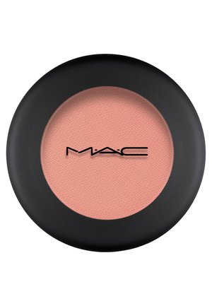 Round blush compact with a matte black exterior. Inside, a soft, peach-colored powder texture. MAC logo in black at the center.
