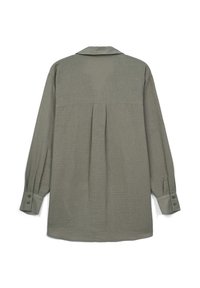 Camicia a maniche lunghe in tessuto verde tenue presenta una piega sul retro, colletto e polsi con bottoni, evidenziando una superficie testurizzata.