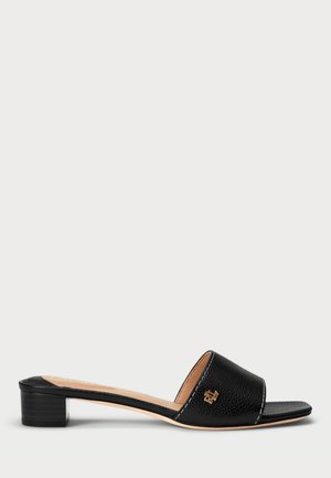 Sort læder slidesandal med lav blokhæl og guldt logo på bred frontrem, beige indersål og åben tådesign.