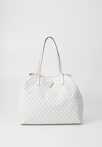 Sac à main blanc Guess avec motif géométrique, deux longues anses et plaque de logo triangulaire au centre à l'avant.