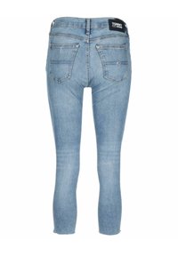 Jeans de mezclilla de color azul claro con un corte ajustado, que presentan una cintura alta, dos bolsillos traseros y un dobladillo sin terminar en el tobillo. Etiqueta de Tommy Jeans en la cinturilla.