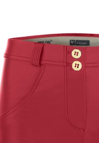 Pantaloni rossi in misto cotone con una texture liscia, due bottoni dorati in vita e dettagli di cucitura discreti. Presentano tasche laterali.