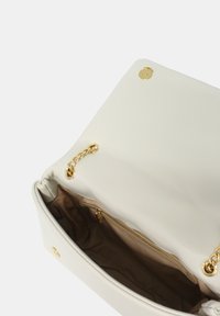 Borsa in pelle bianca con hardware dorato, chiusura circolare e dettaglio chain. L'interno presenta una fodera beige e una tasca con zip.