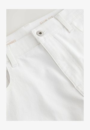 Pantalons en denim blancs slim fit avec une texture lisse. Dotés d'une fermeture à bouton en métal et d'une surpiqûre le long de la taille et des poches.