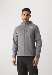 Grijze hooded jack met een voorrits, gemaakt van lichtgewicht materiaal. Bevat een logo op de bovenste linkerborst en zijzakken.