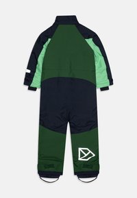 Zaļš un tumši zils izolēts kombinezons ar augstu apkakli, elastīgām aprocēm un baltu logo uz kājas. Iezīmē krāsu salikuma dizainu.