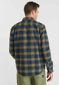 Geplaid flanellen shirt in blauw, groen en beige. Lange mouwen, knoopmanchetten en een rugpand. Heeft een gebogen zoom en een zachte textuur.