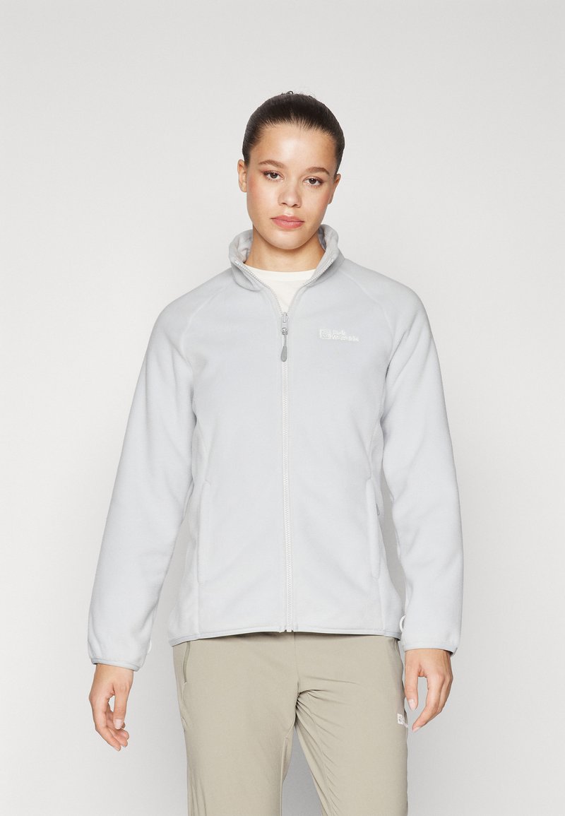 Giacca in pile grigio chiaro con collo alto, zip intera e due tasche laterali. Presenta una texture liscia e un discreto dettaglio del logo sul petto.