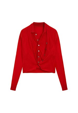 Cardigan rosso a maniche lunghe e cropped con apertura frontale a bottoni, indossato sopra una camicia a maniche lunghe rossa abbinata.