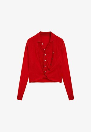Cardigan rosso a maniche lunghe e cropped con apertura frontale a bottoni, indossato sopra una camicia a maniche lunghe rossa abbinata.