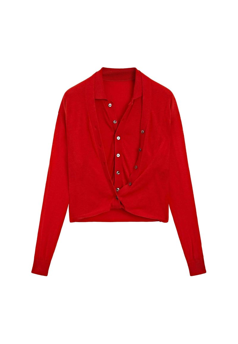 Röd långärmad kort cardigan med knappstängning över en matchande röd skjorta med knappar.